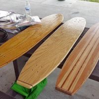 Wooden skateboard decks laid out over a picnic table.