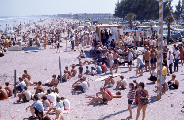 An old photograph looking down at a large group of people on the beach