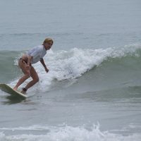 A woman surfing in a white shirt