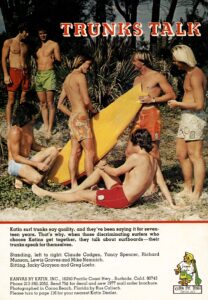EARLY 1970ÕS KATIN AD WITH ( L R ) CLAUDE CODGEN ECSHOF 1996, YANCY SPENCER, ECSHOF 1996, RICHARD MUNSON ECSHOF 2020 WITH BACK TO CAMERA, LEWIS GRAVES, ECSHOF 2004 HOLDING TAIL OF BOARD, MIKE ÒNEMOÓ NEMNICH ECSHOF 2014 FAR RIGHT IN PHOTO, JACKIE GRAYSON KNEELING AND GREG LOERH, ECSHOF 2000 SITTING IN RED TRUNKS. COURTESY KATIN